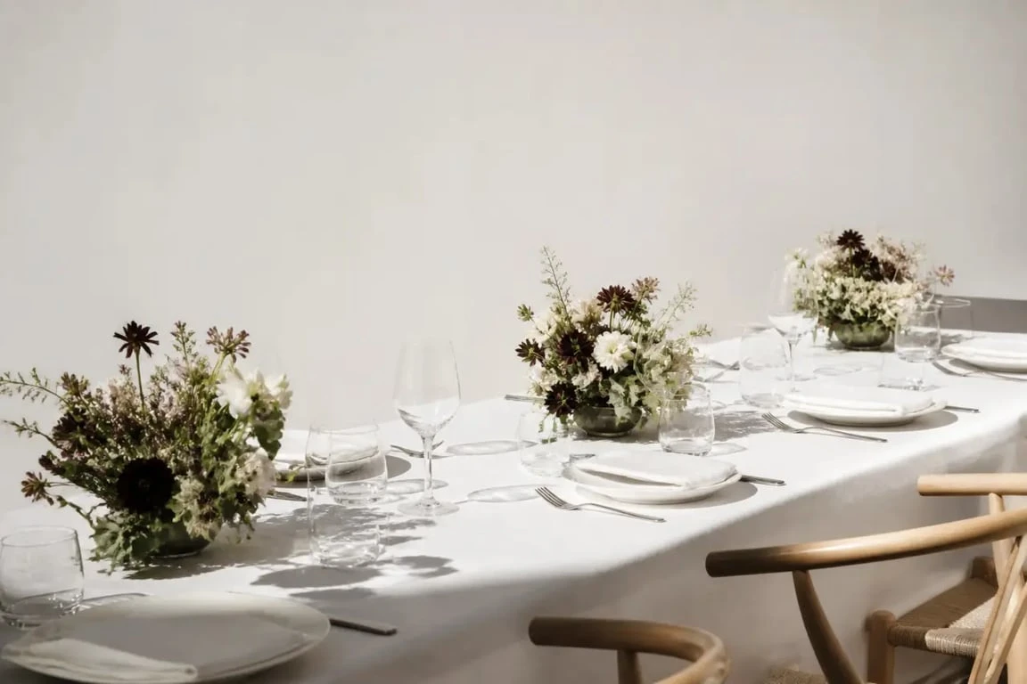 Petite composition florale pour table en série sur une grande tablée de réception